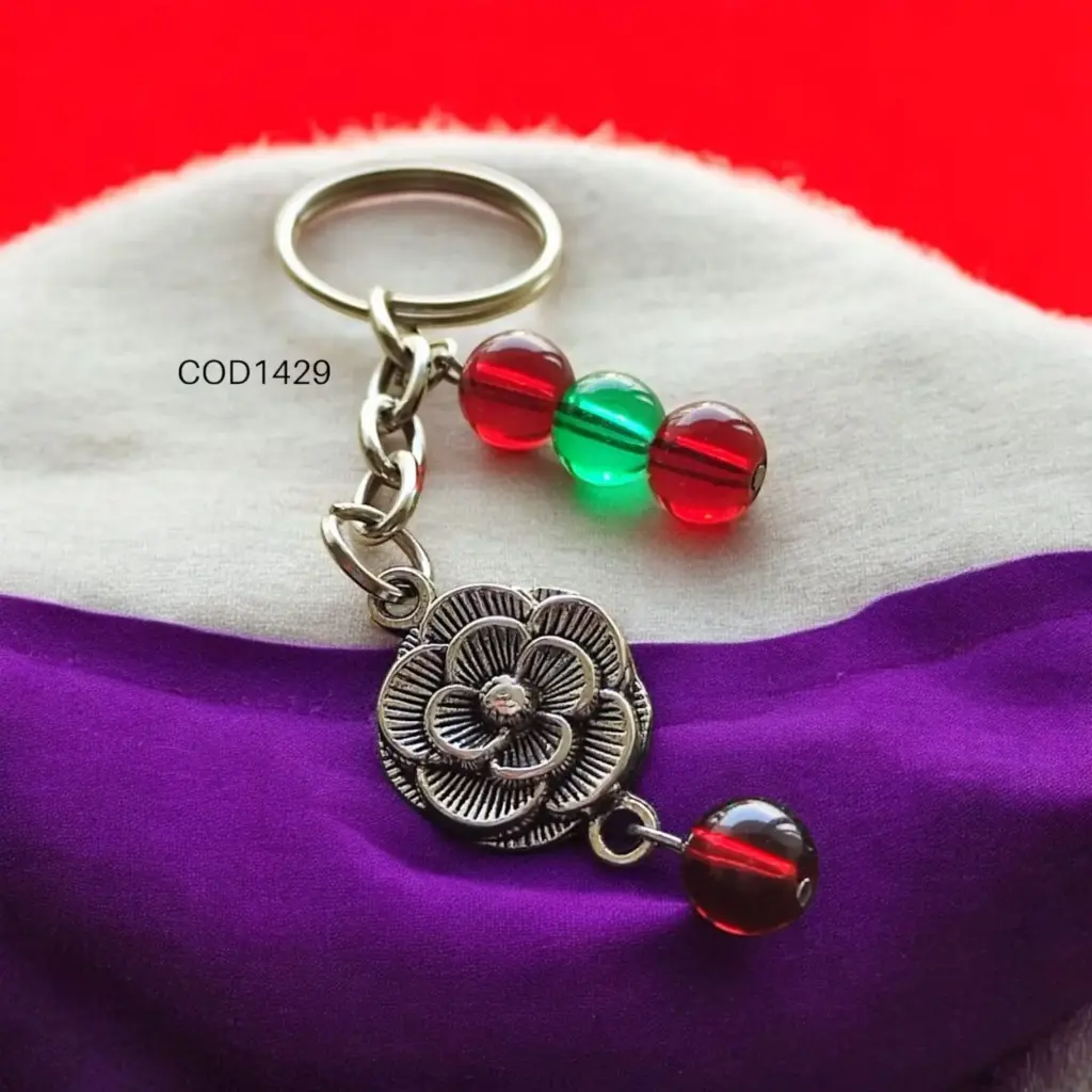 Llavero de flor con perlas rojas y verde.