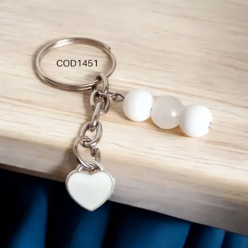 Llavero de corazón con perlas blancas.