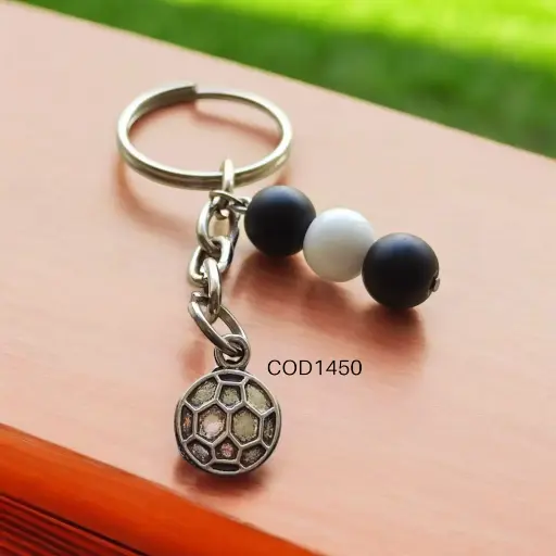 Llavero de futbol plateada con perlas blanca y negro.