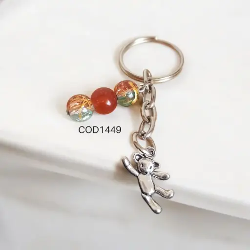 Llavero de oso con perlas naranjas.