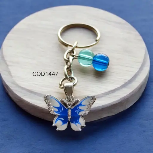 Llavero de mariposa azul con perlas.