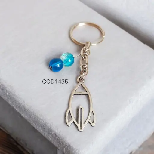 Llavero de cohete con perlas celestes