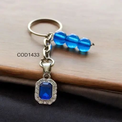 Llavero cuadrado con piedra y perlas azules.
